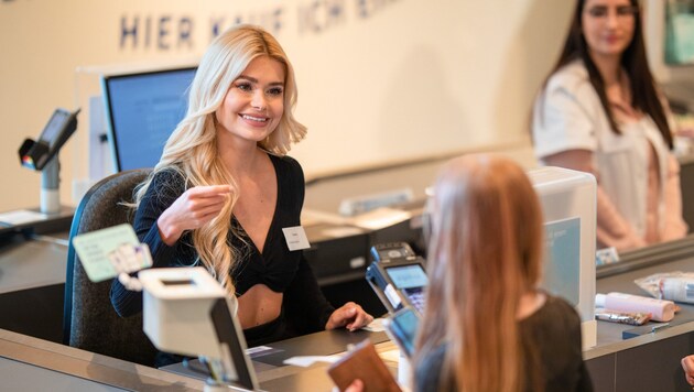 Pamela Reif sits at the checkout in a German drugstore. (Bild: Christoph Schmidt / dpa / picturedesk.com)