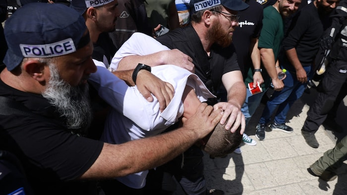 One of the alleged perpetrators is being taken away.