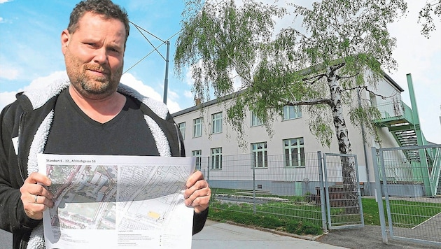 Manuel Kiesling is deputy chairman of the parents' association at Kagran secondary school and a concerned parent and local resident. Here he is holding the plans for the container classes in his hands, which will further increase the problems. (Bild: Klemens Groh, Krone KREATIV)