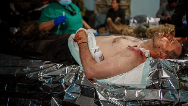 Egy sebesült frontszolgálatos katona elsősegélyben részesül Bachmut közelében. (Bild: AFP)