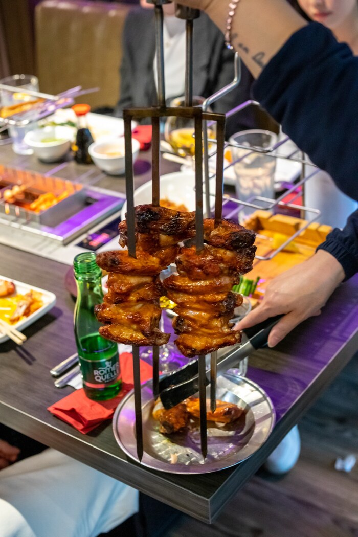Nicht nur selbst grillen: Am Tisch werden gegrillte Chicken Wings serviert.