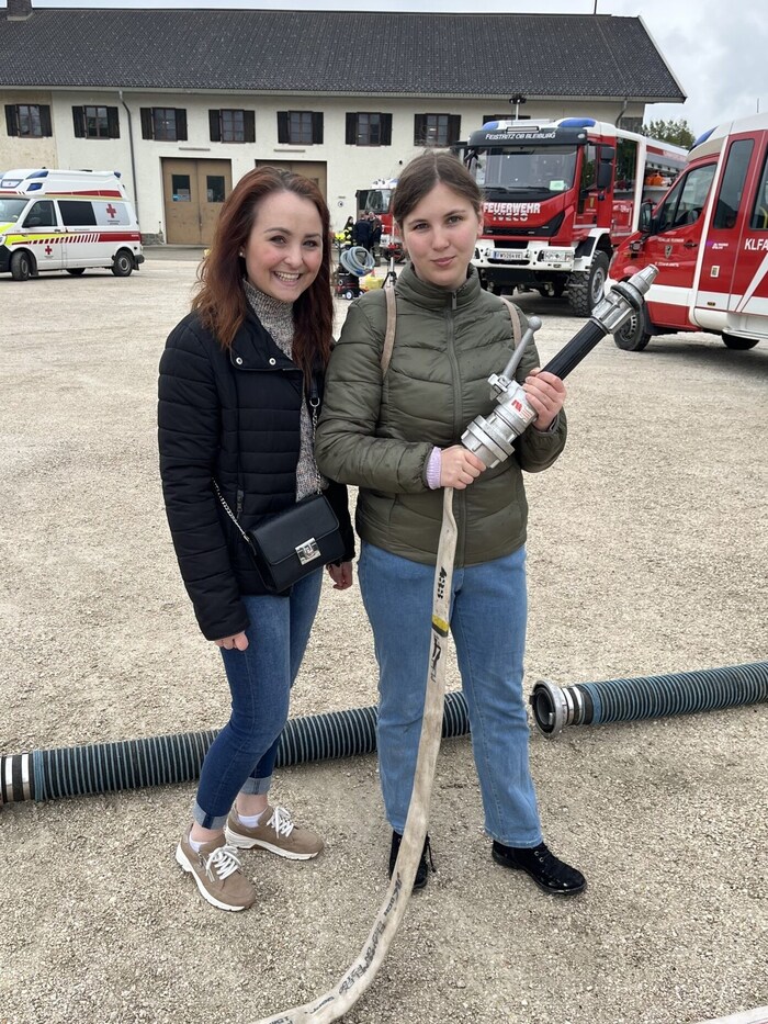 Bei der Feuerwehr wird gezeigt, wie man die Schläuche zusammensteckt.