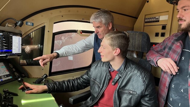 Engine driver Hermann Struber explains the levers in the driver's cab to potential future colleagues Lukas Kaiser and David Christof. (Bild: Roittner Felix)