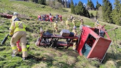 Der Schlepper stürzte rund 50 Meter über steiles Gelände, der Lenker wurde aus der Kabine geschleudert. (Bild: ZOOM Tirol/Krone KREATIV)