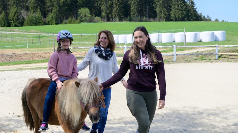 Auf dem Rücken der Pferde: Die kleine Marie fühlt sich sichtlich wohl – und wird von Stöcklhubers Team tatkräftig unterstützt. (Bild: Molnar Attila)