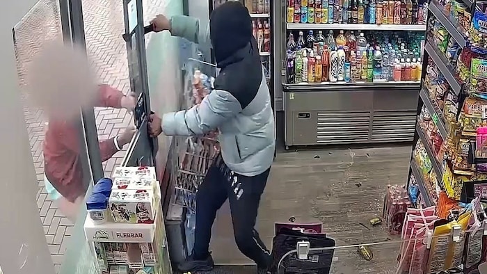Der Angestellte hielt von außen den Eingang zum Laden zu.
