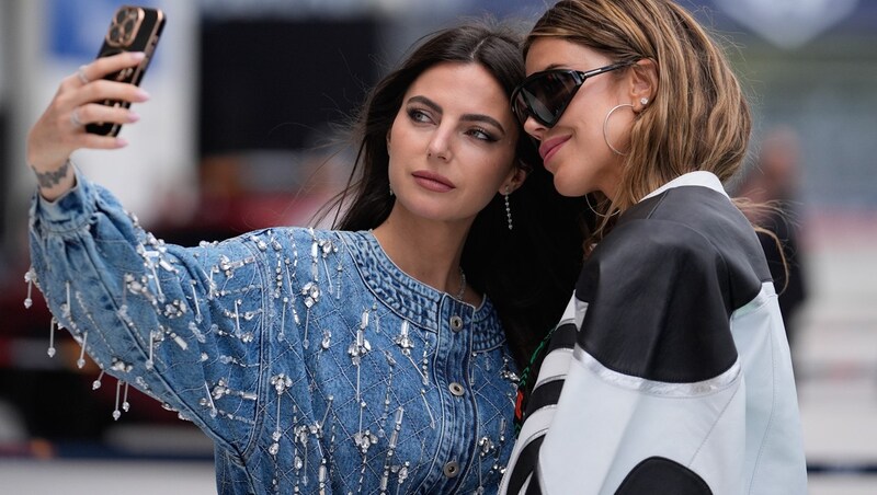 Kelly Piquet (left), girlfriend of Max Verstappen, in selfie mode with a friend (Bild: AP/PA)