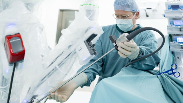 Robot and doctor in scrubs. Operating together. (Bild: Gerhard Berger)