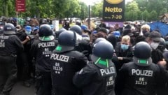 Polizeibeamte stehen bei der Demonstration gegen Tesla neben den Demonstranten. (Bild: APA Pool/APA/dpa/Wilhelm Pischke)