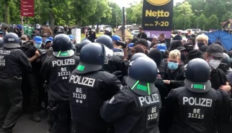 Polizeibeamte stehen bei der Demonstration gegen Tesla neben den Demonstranten. (Bild: APA Pool/APA/dpa/Wilhelm Pischke)