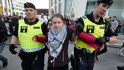 Greta Thunberg wird am Samstagabend von der schwedischen Polizei abgeführt. Sie trägt ein Palästinensertuch. (Bild: APA Pool/APA/AFP/TT NEWS AGENCY/Johan NILSSON)