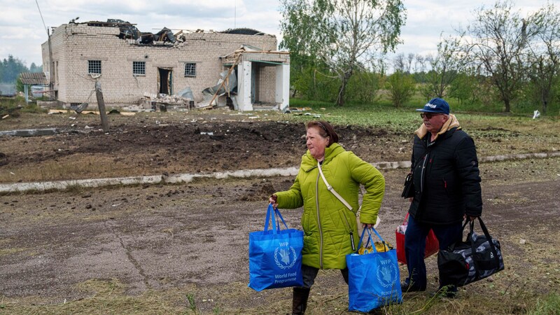 Zivilpersonen mit ihren Habseligkeiten in Wowtschansk (Bild: AP/Evgeniy Maloletka)