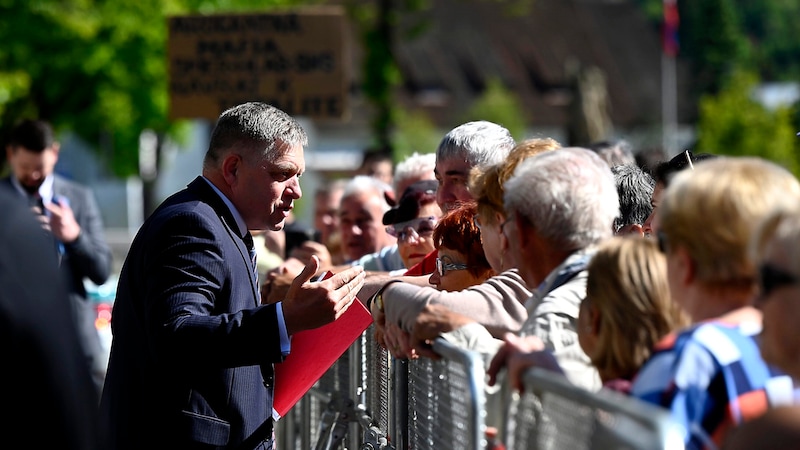 Hier war noch alles in Ordnung: Ministerpräsident Robert Fico im Gespräch mit Menschen vor der Regierungssitzung (Bild: APA/AP)