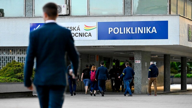 Police officers and media representatives in front of the hospital where the Prime Minister is lying. (Bild: APA/AP)