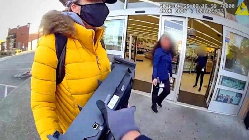 Kadın (resimde) elinde çalıntı para çekmecesi ile doğruca şaşkın bir polis memurunun üzerine koştu. (Bild: kameraOne (Screenshot))