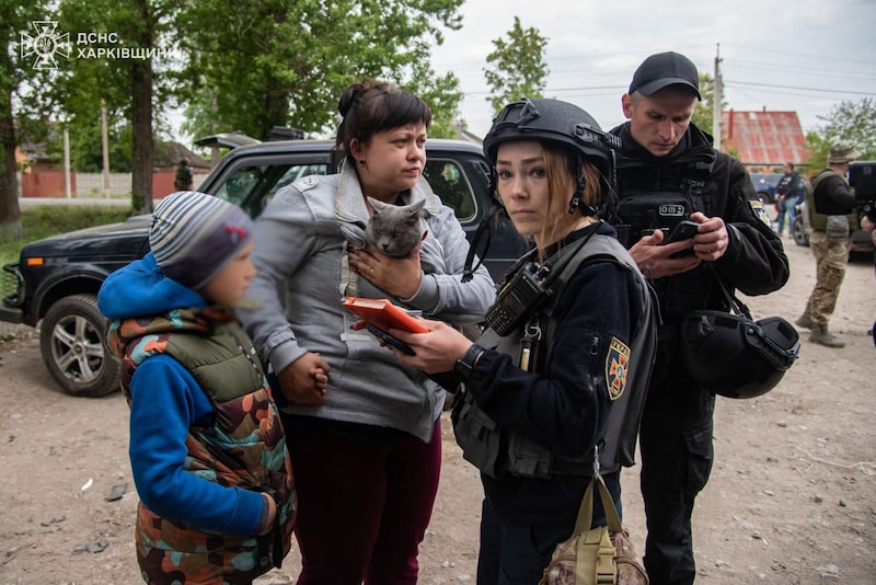 Polizistinnen und Polizisten bringen Zivilisten in Charkiw vor russischen Luftangriffen in Sicherheit. (Bild: APA/AFP/Ukraine Emergency Service/Handout)