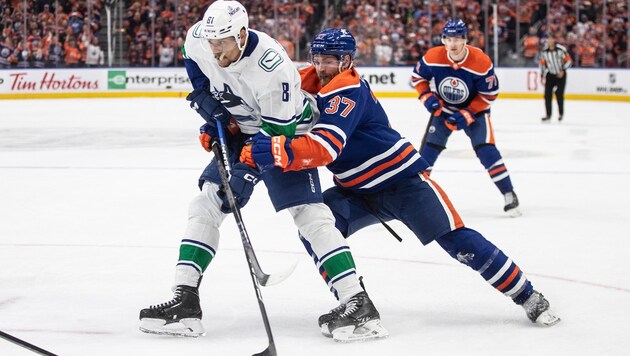 Dakota Joshua von den Vancouver Canucks (links) im Duell mit Warren Foegele (Nummer 37) von den Edmonton Oilers  (Bild: AP)