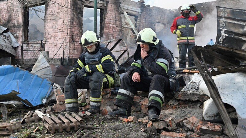 Erschöpfte Feuerwehrmänner ruhen sich nach ihrem Einsatz aus. (Bild: APA/AFP/SERGEY BOBOK)