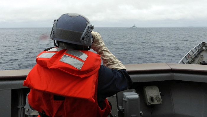 Ein Angehöriger der taiwanischen Streitkräfte nimmt ein chinesisches Militärschiff vor der Küste ...