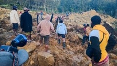 Rettungsmannschaften machen sich ein erstes Bild vom Ausmaß des katastrophalen Erdrutsches. (Bild: APA/AFP/STR)