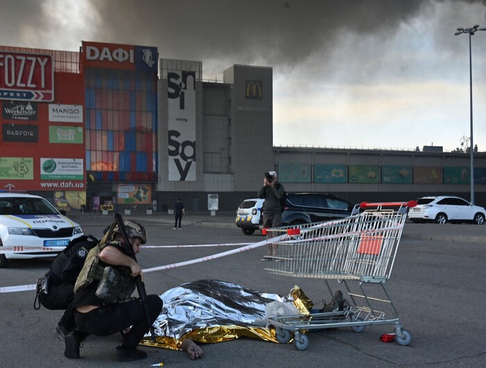 A Ukrainian policeman covers the body of a man killed in the attack.