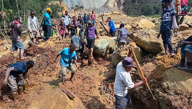 We are searching for survivors with shovels and hands. (Bild: AP/Mohamud Omer/International Organization for Migration)