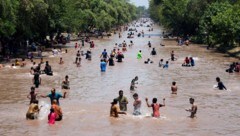 People are looking to cool off. (Bild: AP ( via APA) Austria Presse Agentur/K.M. Chaudary/AP)