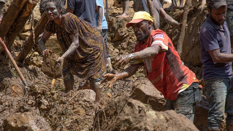 Az emberek puszta kézzel ásnak az eltemetett áldozatok után. (Bild: AFP/UN DEVELOPMENT PROGRAMME)