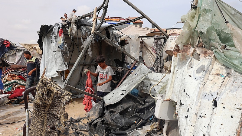 Bewohner des Camps begutachten ihre zerstörten Unterkünfte. (Bild: APA/AFP/Eyad BABA)