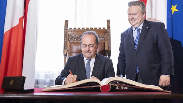 Former President François Hollande signing the Golden Book of the City of Vienna. (Bild: APA/TOBIAS STEINMAURER)