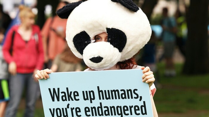 "Wake up, people. You are endangered too" can be read on this sign held by a participant.