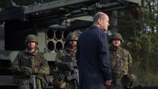 Archivbild: Der deutsche Kanzler Olaf Scholz bei einem Truppenbesuch im Jahr 2022 – im Hintergrund steht ein Mehrfachraketenwerfer vom Typ MARS-2. (Bild: AFP/APA/Ronny Hartmann)