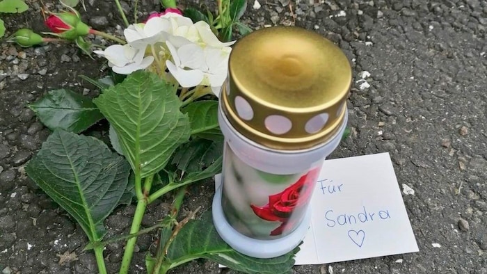 Kocası tarafından vurularak öldürülen Sandra için olay yerinde mumlar ve çiçekler.