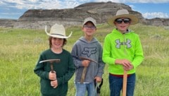 v.l.n.r: Liam Fisher, Kaiden Madsen und Jessin Fisher entdeckten bei einer Wanderung die fossilen Knochen eines jungen Tyrannosaurus rex.  (Bild: AP/David Clark/Giant Screen Films)