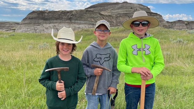 v.l.n.r: Liam Fisher, Kaiden Madsen und Jessin Fisher entdeckten bei einer Wanderung die fossilen Knochen eines jungen Tyrannosaurus rex.  (Bild: AP/David Clark/Giant Screen Films)