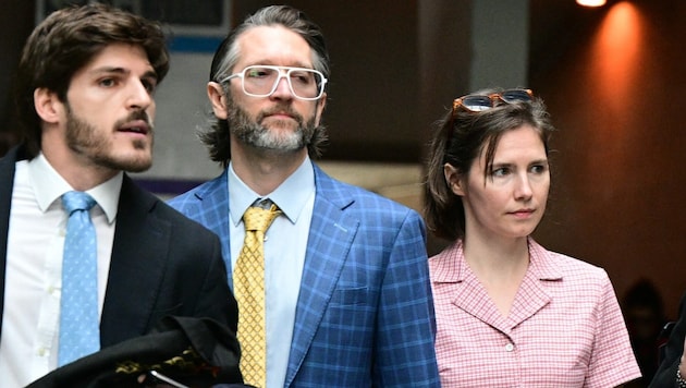 Amanda Knox with her husband (next to her) and lawyer in Florence (Bild: AFP/Tiziana Fabi)