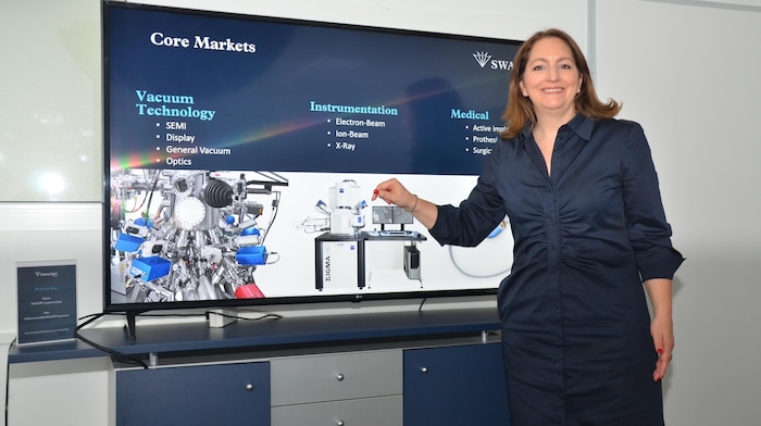 Manuela Vogt zeigt das Gehäuse des Elektronen-Mikroskopes für Zeiss als Referenzprodukt.