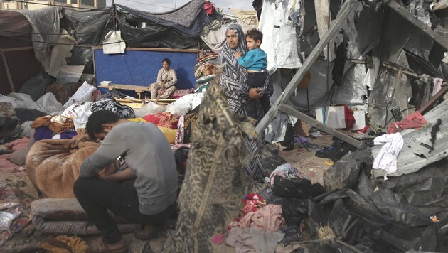 Civilians are in constant danger amid the turmoil of war in the Gaza Strip. Here a woman with her child in a destroyed tent city in Rafah. (Bild: AP/AP Photo/Jehad Alshrafi)