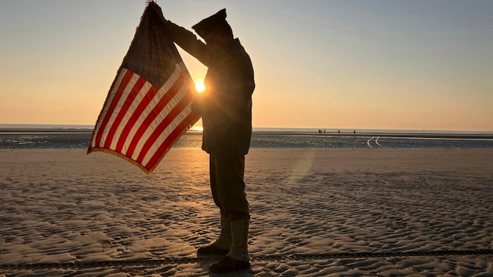 Der Frazose Christophe Receveur mit einer US-Flagge auf Utah Beach.