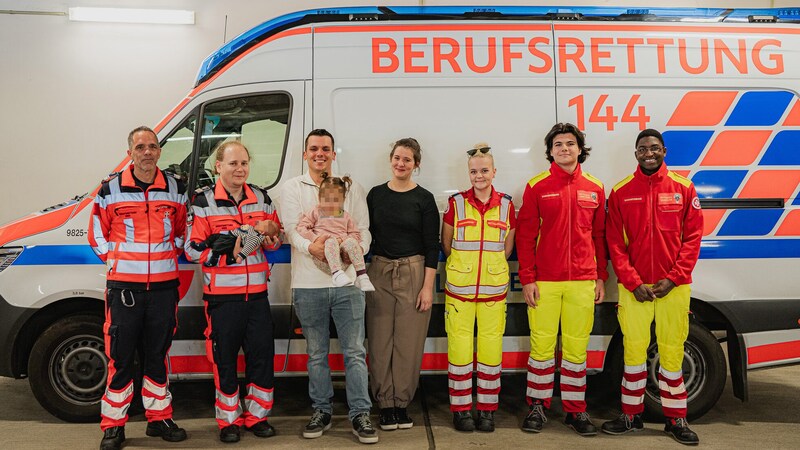 Notfallsanitäter Markus, Notarzt Fritz mit dem kleinen Jonas Elian, Papa Marcel mit Tochter Pia, Mama Nike, Rettungssanitäterin Lisa, Rettungssanitäter Maxwell und Rettungssanitäter Loris (v.l.n.r.) (Bild: Berufsrettung Wien, Krone KREATIV)