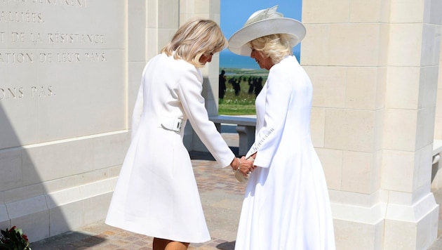 Kraliçe Camilla ve Brigitte Macron birlikte çiçek bıraktı. Utanç verici bir protokol aksiliği yaşandı. (Bild: Action Press/APA/AP/Chris Jackson)