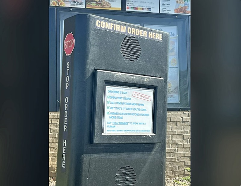 Fotoğrafta da görülebileceği gibi, hoparlörün altında İngilizce bir not var: "AI is being trained here." Sanal çalışanın işini kolaylaştırmak için müşterilerden belirli davranışları benimsemeleri isteniyor. (Bild: Screenshot/Reddit)