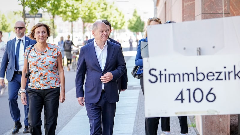 Deutschlands Bundeskanzler Olaf Scholz (SPD) mit seiner Ehefrau Britta Ernst auf dem Weg zur Stimmabgabe am Sonntag (Bild: APA Pool/APA/dpa-Pool/Kay Nietfeld)