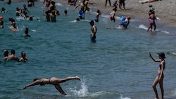 Badende an einem Strand in Athen (Bild: AFP/Aris Messinis)