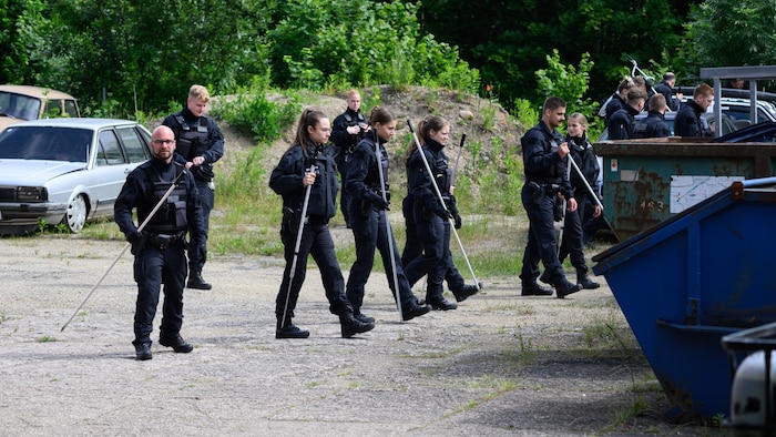 Polizisten suchen auf einem Firmengelände nach der vermissten Schülerin.
