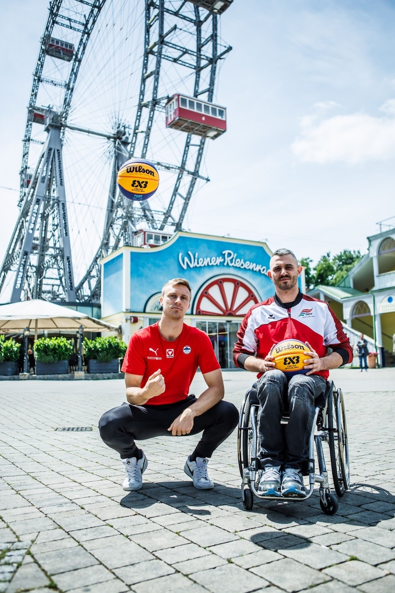 Mathias Linortner and Mehmet Hayirli on the ground in front of the Vienna Giant Ferris Wheel. (Bild: © APhotography / A. Pichler-Kröss/Basketball Austria)