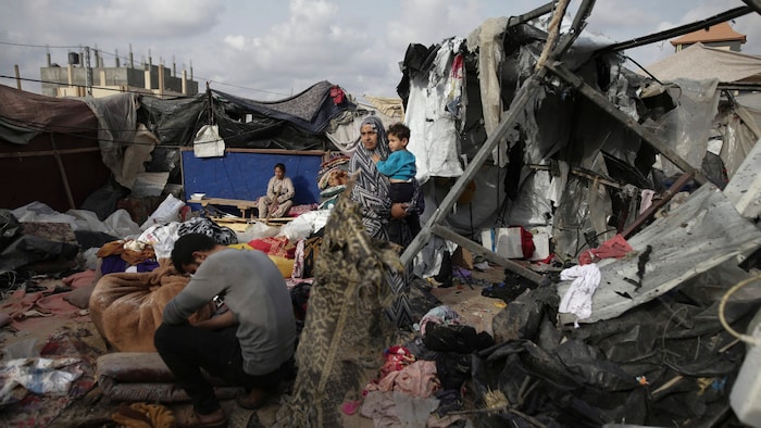 Displaced Palestinians inspect their tents after Israeli bombardment.