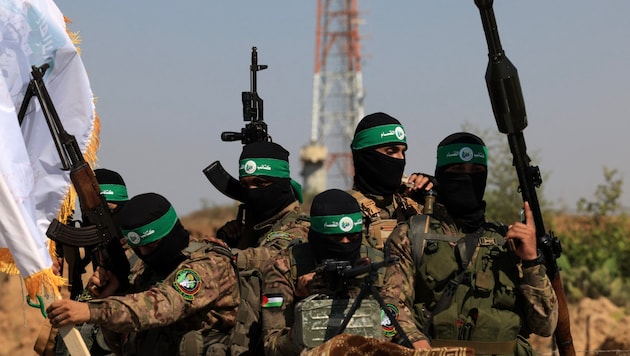 Temmuz 2023'te Gazze Şeridi'nde bir geçit töreninde Hamas savaşçıları (arka planda İsrail gözetleme istasyonu) (Bild: APA/AFP/MAHMUD HAMS)