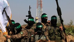 Hamas-Kämpfer bei einer Parade im Gazastreifen im Juli 2023 (Im Hintergrund eine israelische Überwachungsstation) (Bild: APA/AFP/MAHMUD HAMS)