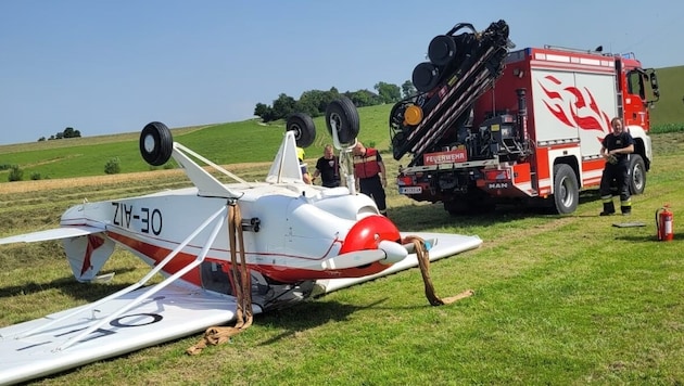 Az egy hajtóműves kétüléses repülőgép a leszállást követő forduló manőver során felborult, és a tetején állt meg. (Bild: Bfkdo Amstetten / FF Seitenstetten-Markt)